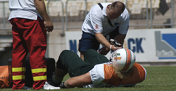 Medic Examining Football Player for Injury